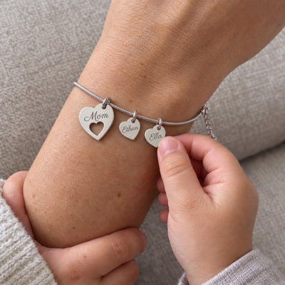 Silver Mom bracelet worn by a mother holding her child